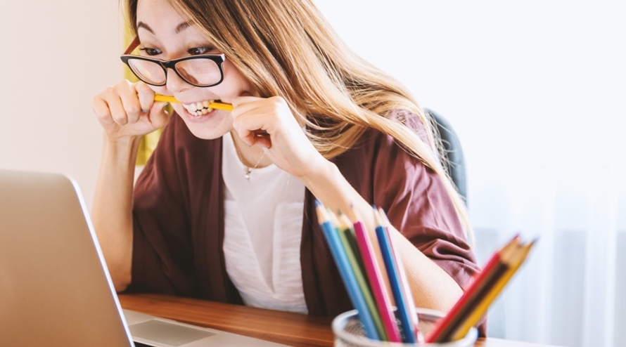Stressed woman biting a pencil