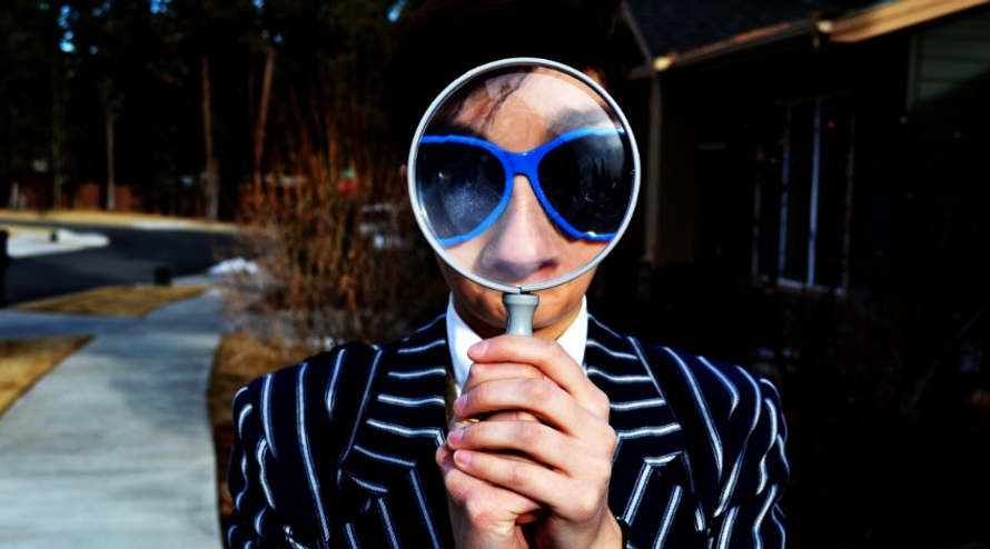 Person looking through a magnifying glass